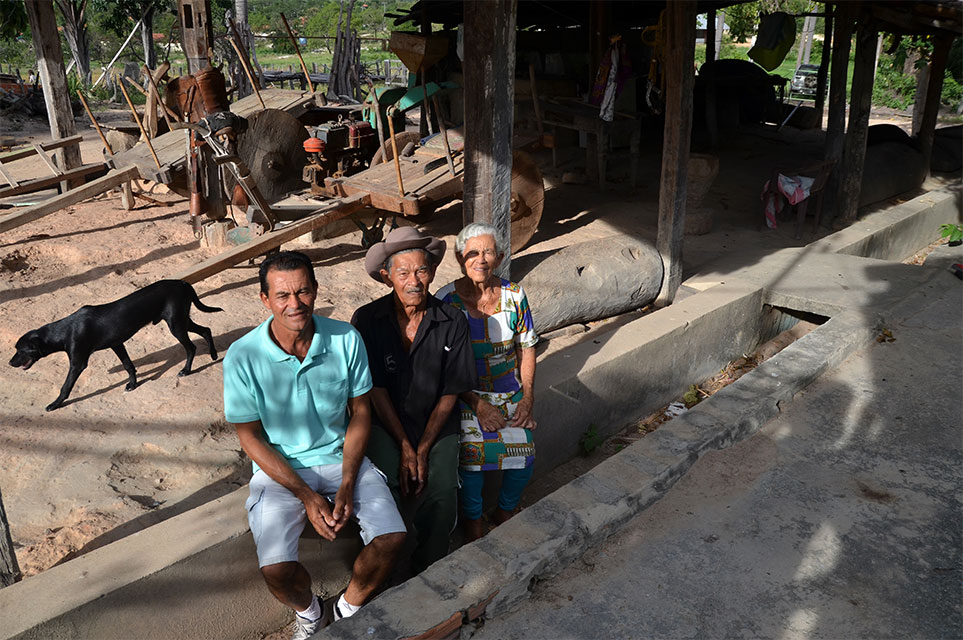 Dalvina, Seu Deca e o filho Joaquim sentados no rego sem água nos fundos da casa. Foto: Gilberto Alves/Especial para o Metrópoles