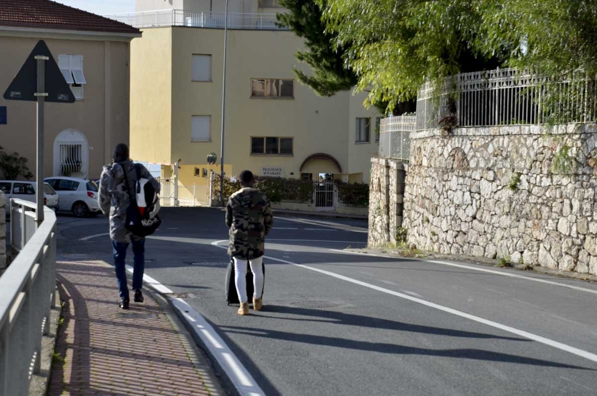 Migrantes caminham pelas rodovias de Grimaldi, a última vila italiana antes da fronteira